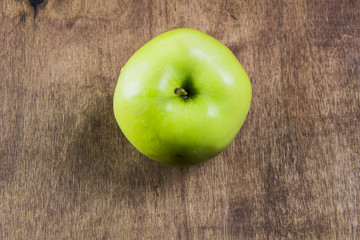 Green organic healthy apples in bowl on wooden board. Healthy food
