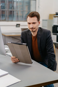 Man using digital tablet while sitting at desk