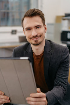 Smiling man using digital tablet in office