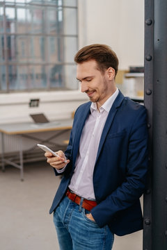 Businessman standing reading an sms on his mobile