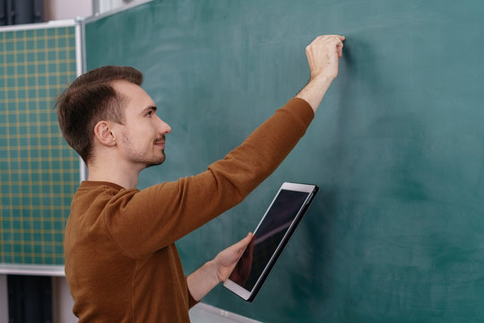 Male teacher or mature student writing on a board