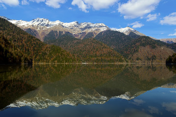 Riza lake, yellow autumn-green forest and white snow peaks