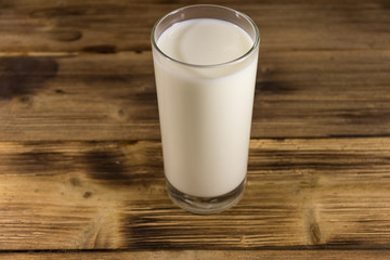 Glass of milk on wooden table
