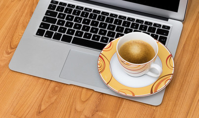 Kaffeetasse auf einem Laptop