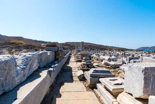 Delos Island, Greece.  The Sacred Way with ancient ruins in Archaeological Site of Delos island, Cyclades, Greece