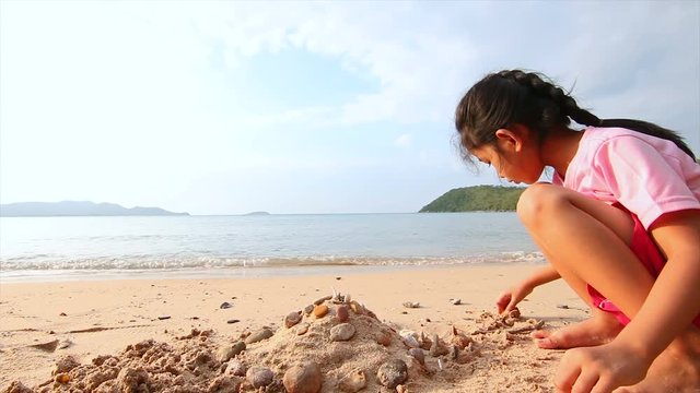 4K Asian little girl playing on the beach with evening ambient light and sound