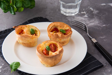 Salty snack. Homemade muffins with cheese, tomatoes and basil.