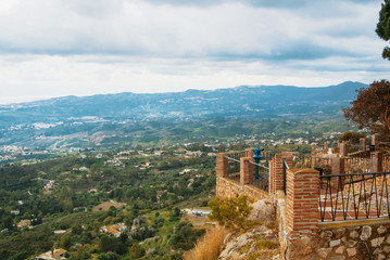 View point in the park of Mijas, a blue coin telescope and a beautiful panoramic aerial view to Mediterranean sea and surroundings of Fuengirola town on winter cloudy day, Andalusia, Spain.