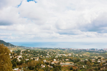 Aerial panoramic beautiful view from the park of Mijas, seascape of Mediterranean sea and surroundings of Fuengirola town on winter cloudy day, Andalusia, Spain.