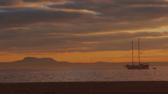 Silhouette two-masted yacht at the beautiful sunset on the sea