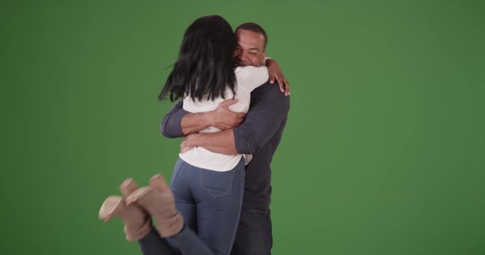 Couple meeting and embracing after not seeing each other on green screen. On green screen to be keyed or composited. 