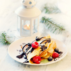 Delicious Christmas sweet breakfast. Crepes with berries.