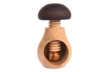 Wooden mushroom shape nutcracker isolated on white background. Screw type nut cracker with hazelnut.