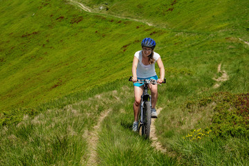 Obraz premium Woman rides bicycle up in the mountains