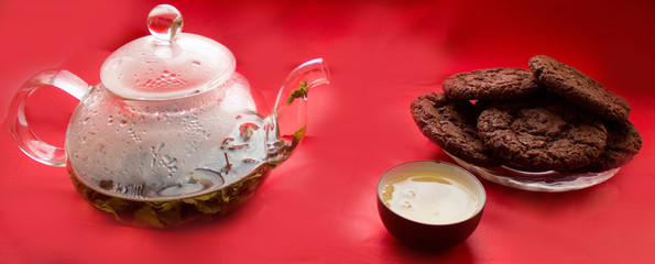 Obraz na płótnie Canvas still life, transparent glass teapot, cup with tea, cookies