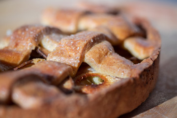 Macro photography of tasty pear tart on wood cutting board