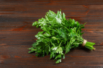 A bunch of green parsley on a wooden table.
