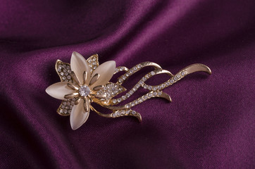 gold brooch flower with gems and moon stone on silk