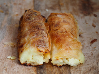 Strukli, traditional Croatian cheese snack on wooden background. Sweet or salty.