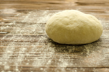 Fototapeta na wymiar Dough on wooden background