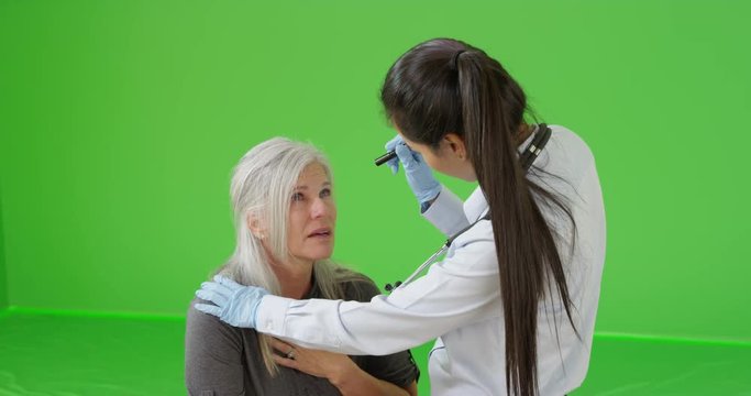An older woman gets help for her sickness on green screen. On green screen to be keyed or composited. 