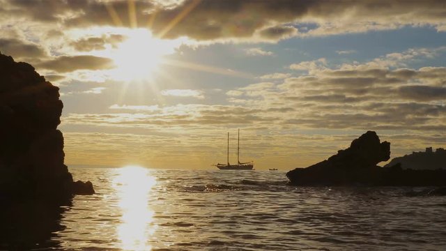 Silhouette two-masted yacht at the beautiful sunset on the sea
