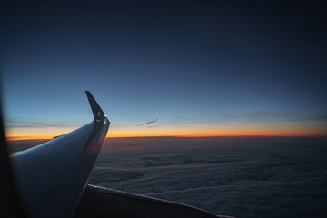 Obraz premium aerial view of plane wing in sunrise during flight