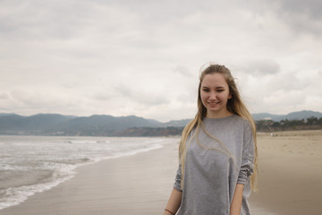 teen girl walking on Santa Monica beach in cloudy november
