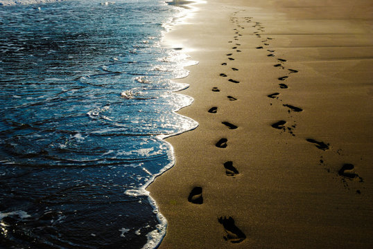 Two pairs of footprints in the sand on the beach