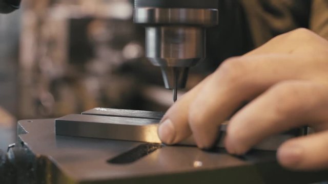 Close up of working milling machine and hands of the worker in workshop