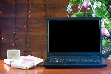 Christmas laptop stands near a Christmas tree, a free space.