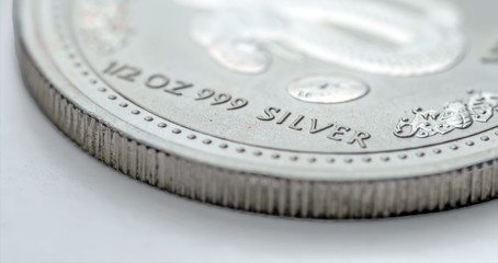 A fragment of a old silver coin weighing 1/2 troy ounce. Selective focus..