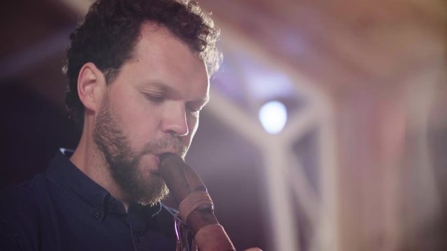 Close up portrait of musician playing ethnic flute