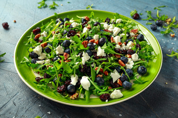 Fresh Blueberries, Cranberry salad with arugula, nuts, feta cheese, olive oil, herbs. Morning, breakfast healthy food.