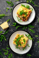 Homemade lasagna with minced beef bolognese and bechamel sauce topped wild arugula, parmesan cheese