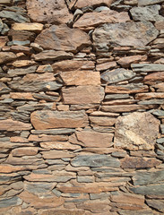 outer wall of a house made of flat red rock