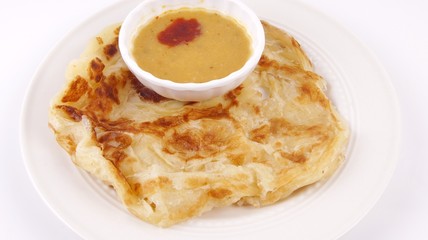 Malaysian favorite breakfast meal. Roti canai or flatbread with dhal curry isolated on white