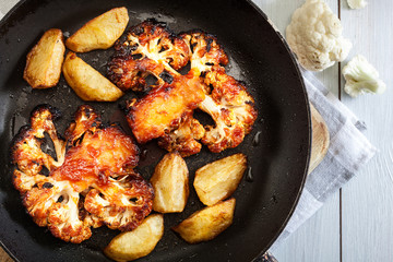 Vegetarian roasted cauliflower steak with herbsand fried potatoes