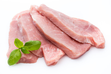 Fresh pork fillet with basil on a white background.
