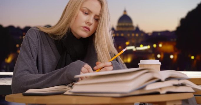 Smart blonde Caucasian woman in Rome does research for school assignment