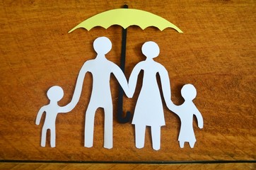 Familie geschützt von einem Regenschirm.