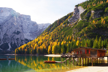 Fototapeta premium Amazing view of Braies Lake - Lago di Braies - with autumn forest and mountains reflected in surface lake water, Dolomites, Italy, Europe