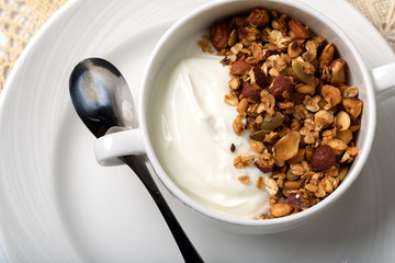 Healthy breakfast: Greek yogurt with homemade granola in a white bowl