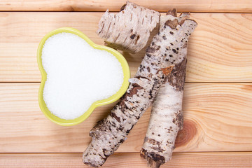 Xylitol - sugar substitute. Birch sugar on wooden background.