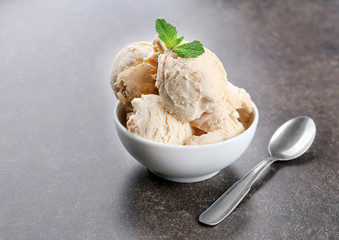 Delicious caramel ice cream in bowl on table