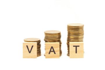 Word Vat Concept on wooden block over on stacked coins.