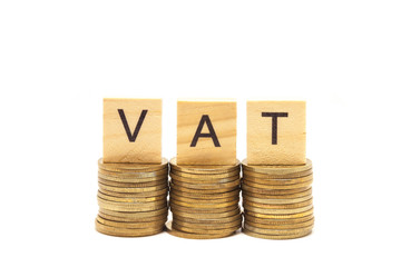 Word Vat Concept on wooden block over on stacked coins.