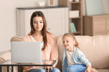 Busy young woman with daughter in home office