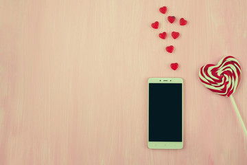 Valentine's Day, heart shaped lollipops and phone, space for text