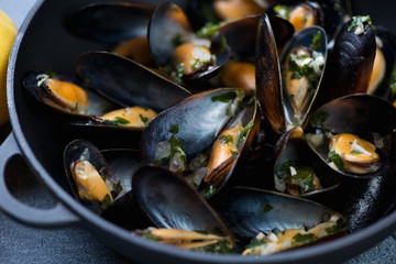 Close-up of freshly cooked mussels in a cast-iron pan, selective focus, shallow depth of field